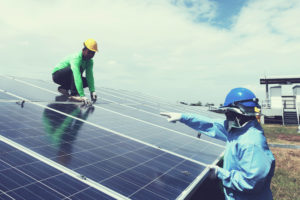 two man repairing solar panels